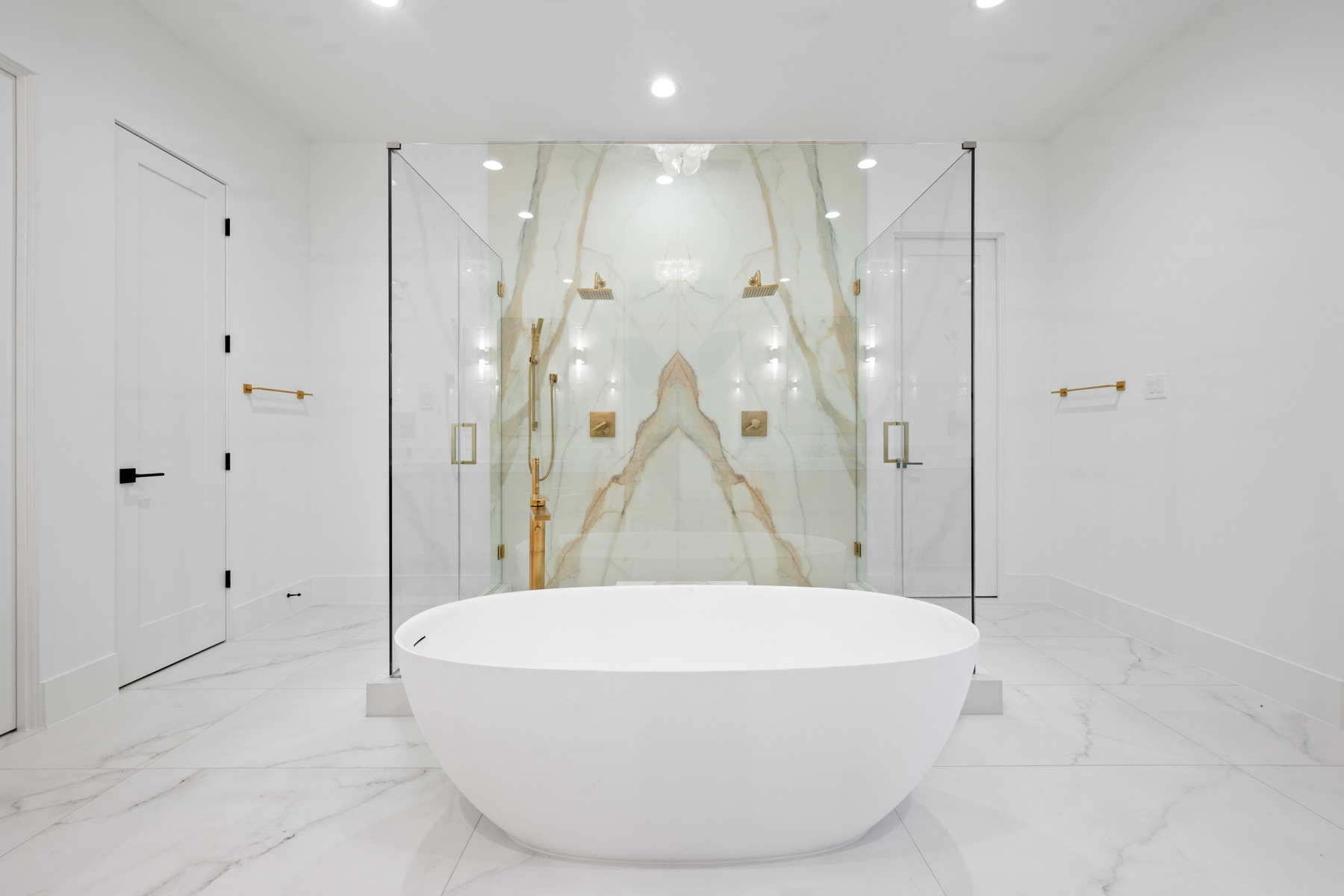 Freestanding tub and book-matched marble bathroom fabricated by Cangelosi Company