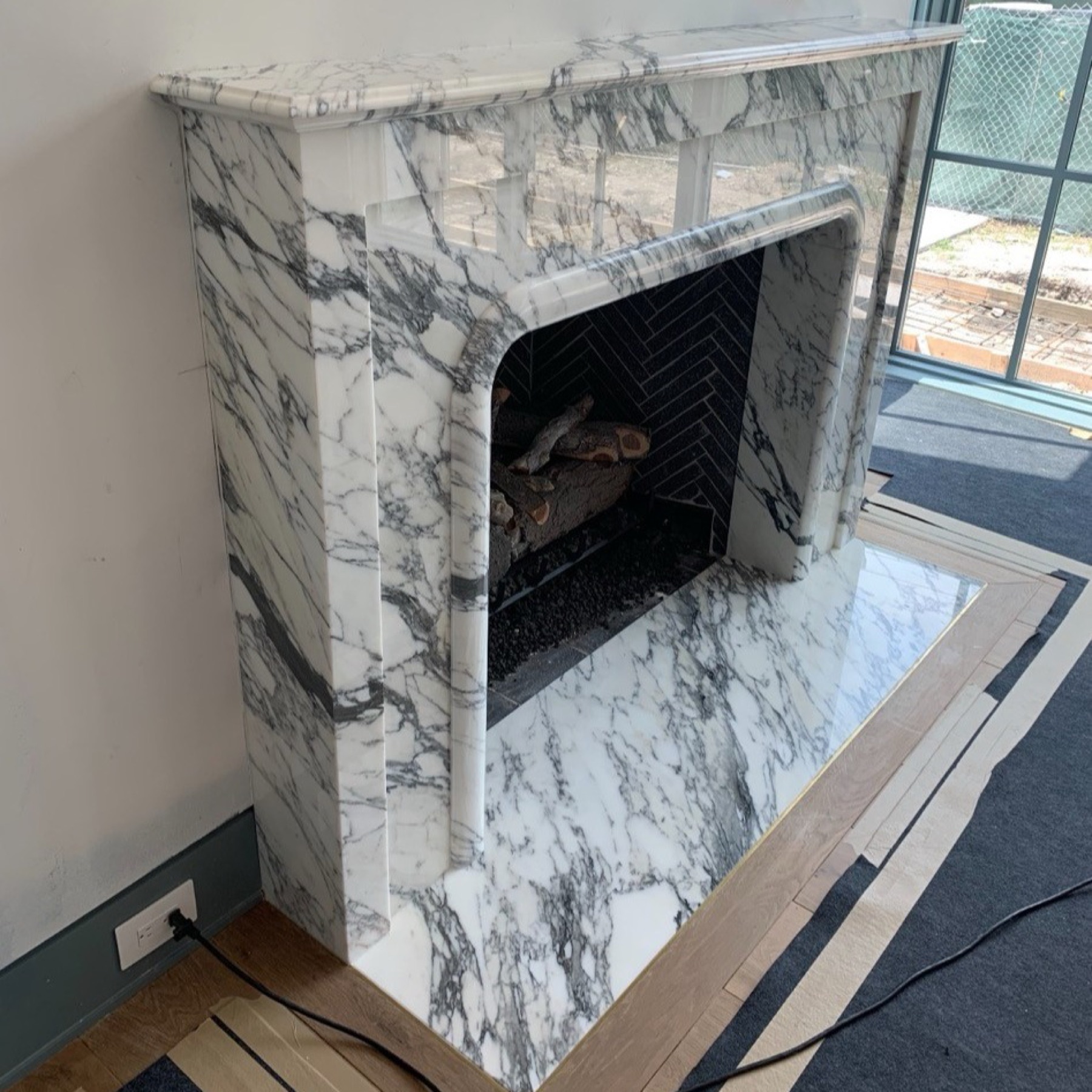 Carved natural stone fireplace surround fabricated by Cangelosi Company