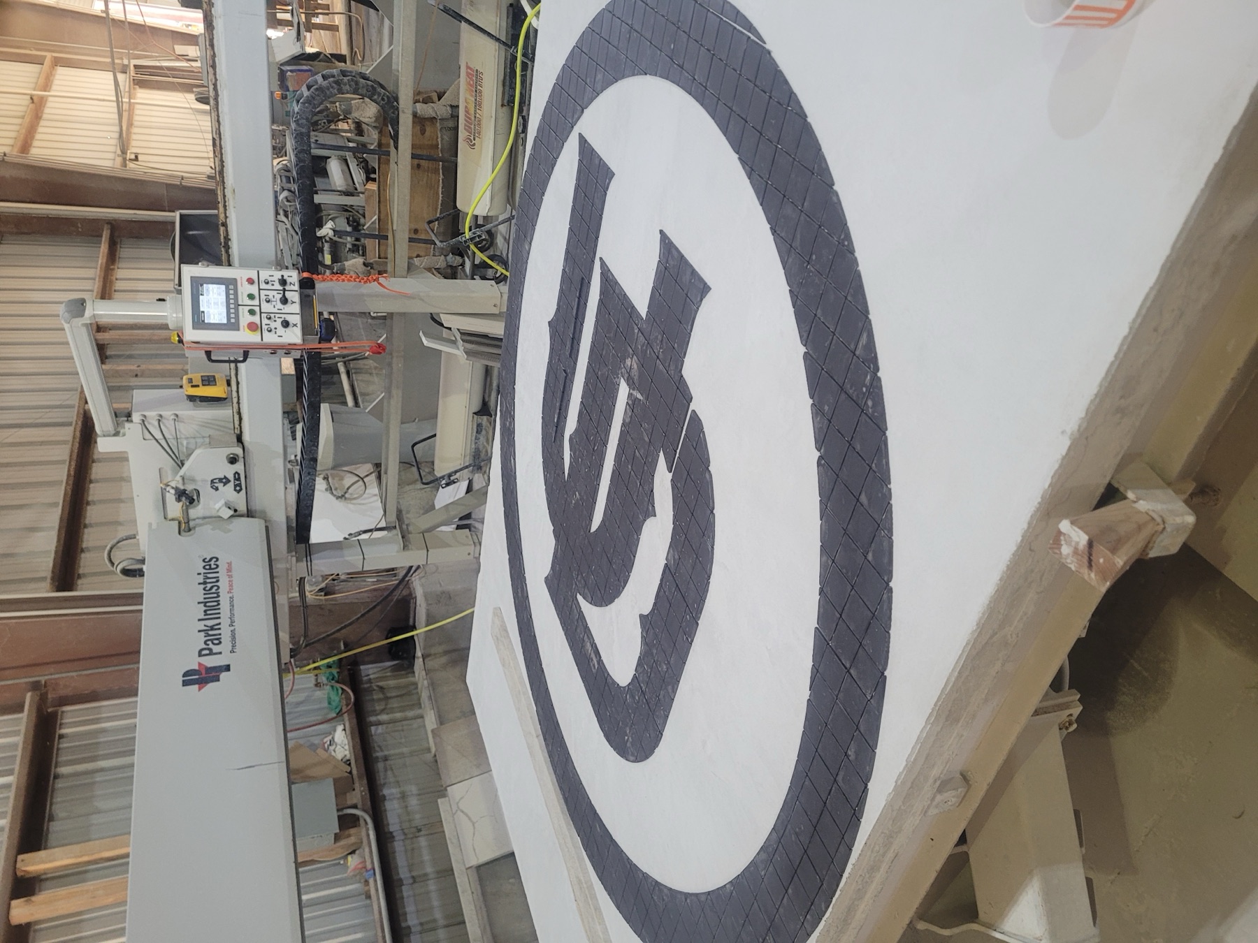 5-axis CNC waterjet cutting a stone medallion at Cangelosi Company